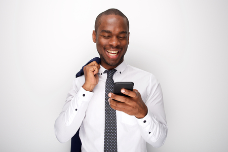 Portrait of cool african american businessman looking at text message on mobile phoneの写真素材