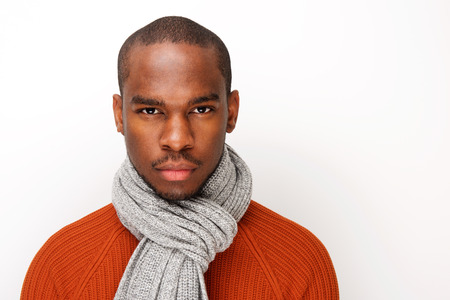 Close up front portrait of handsome young black man with scarf posing against white backgroundの写真素材