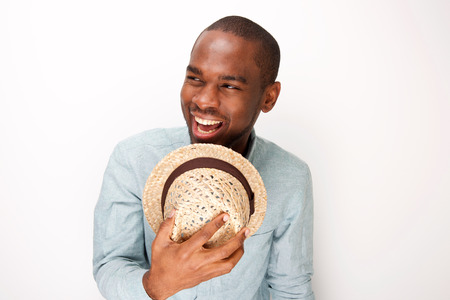 Close up portrait of african american man laughing with hat against white background