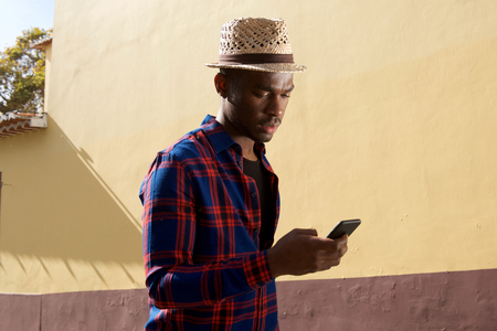 Side portrait of african american man looking at mobile phoneの写真素材