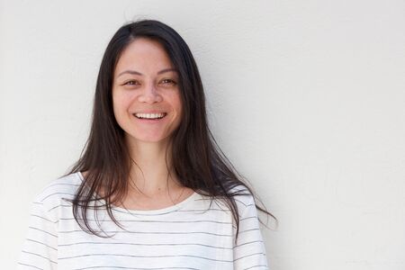 Close up horizontal portrait of young asian woman smiling against white background