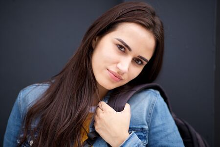 Close up portrait of beautiful young woman against dark backgroundの写真素材