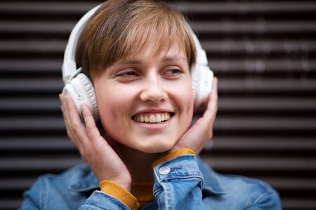 Close up portrait of young woman enjoying music with headphonesの写真素材