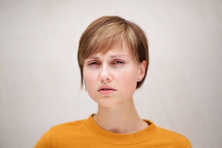 Close up portrait of beautiful young woman with short hair against white backgroundの写真素材