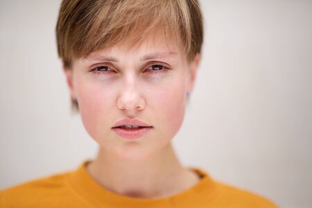 Close up front portrait of young woman with short hair staringの写真素材
