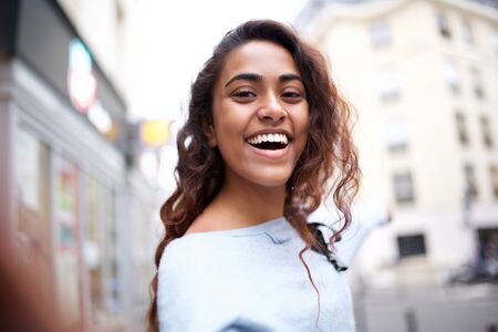 Portrait of beautiful young woman smiling while taking selfieの写真素材