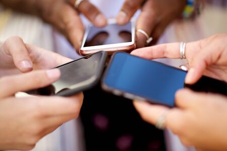 Close up group of young women hands holding mobile phones