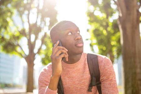 Close up portrait of african american man talking with mobile phone outside