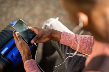 Close up portrait of african american man listening ti music with mobile phone and earphones
