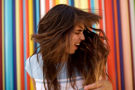 Close up portrait of happy young woman shaking her long hairの写真素材