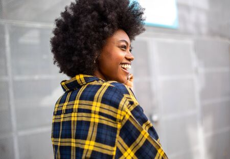 Portrait of cheerful young black woman walking outsideの写真素材