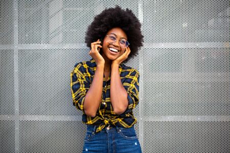 Portrait smiling young black woman with afro hair talking cellphoneの写真素材