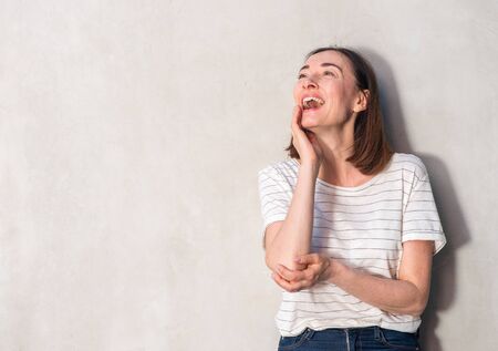 Portrait of beautiful older woman laughing against white wall