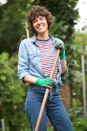 Portrait of smiling woman gardener with tools in gardenの写真素材