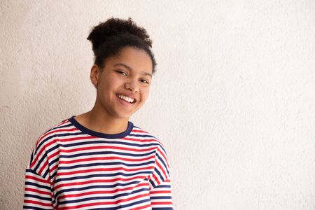 Portrait of african american girl smiling by white backgroundの写真素材