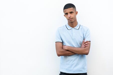 Portrait of young arabic man posing by white background with arms crossedの写真素材