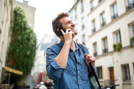 Close up portrait happy man talking with mobile phone in and looking away