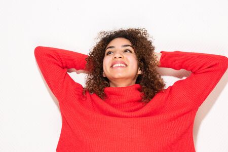 Close up portrait of happy young African american woman with hands behind head