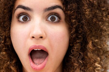 Close up portrait of surprised young woman with mouth wide openの写真素材