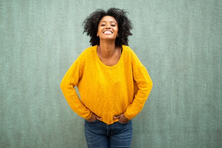 Portrait cheerful young black woman smiling against green backgroundの写真素材