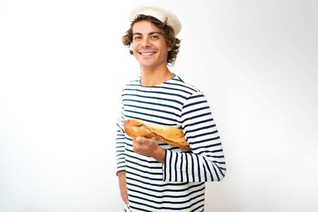 Portrait smiling young French man with beret and baguette in hand against isolated white backgroundの写真素材