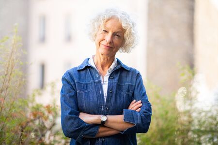 Portrait attractive older woman posing outside with arms crossedの写真素材