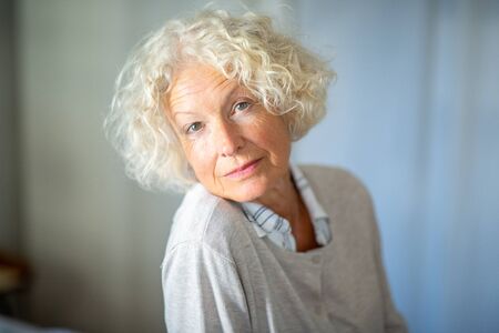 Close up portrait beautiful older woman staringの写真素材