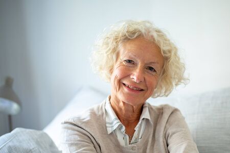 Close up portrait happy elderly woman relaxing at home