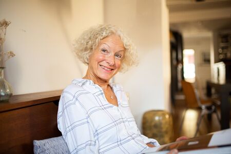 Close up happy older woman sitting at home