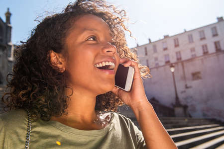 Close up portrait happy young woman talking with cellphone in city
