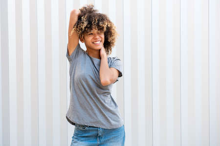 Portrait confident african american girl smiling with hands behind headの写真素材
