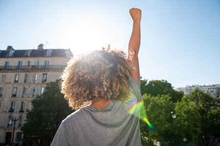 Portrait from behind african american woman with arm raised fistの写真素材