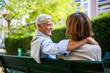 Full body portrait smiling couple walking with suitcase on streetの写真素材