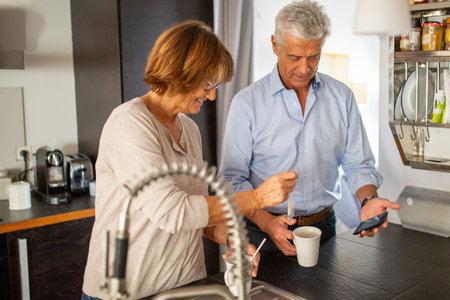 Portrait from back of older couple walking on street with suitcase. Woman smilingの写真素材