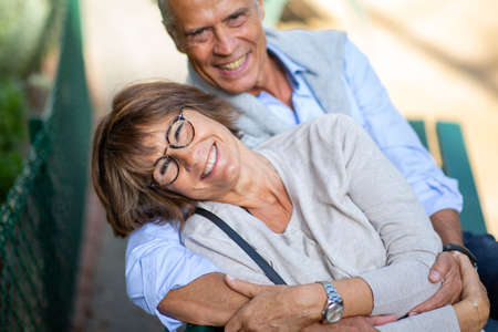 Portrait from back of older couple sitting on park bench
