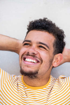 Close up portrait smiling young african american mixed race man with hands behind head