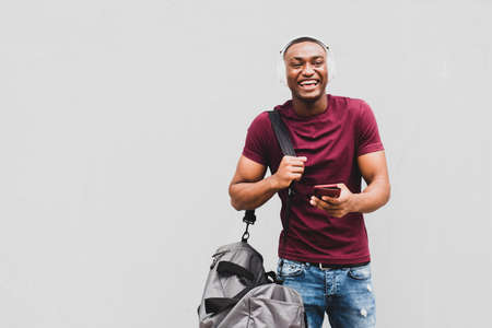 Side portrait smiling African american man sitting outside in city using mobile phoneの写真素材