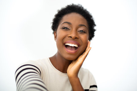 Portrait happy young African amercing woman taking selfie with hand to face