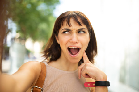Full body portrait young woman walking with bag and cellphone outdoors