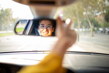 Portrait of a beautiful young woman standing in front of her car outside in the city