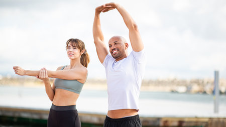 duo starts their day with a rejuvenating stretching session by the waterfront, embracing fitness