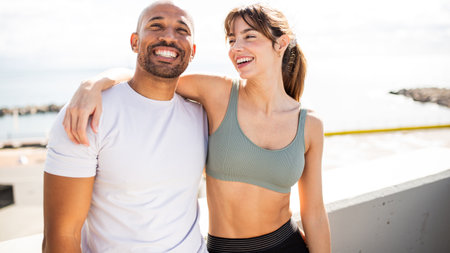 cheerful couple embracing their active lifestyle by the ocean, radiating happiness and motivation...