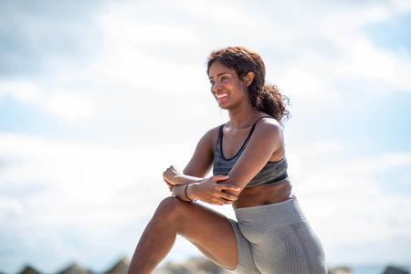Smiling woman takes a break outdoors, leaning on her knee