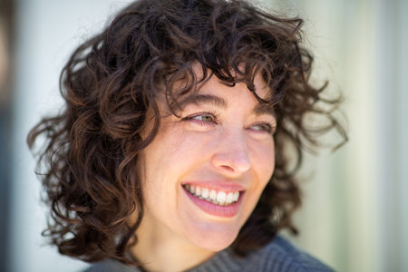 Close-up portrait of pretty young woman with short hair looking away and smilingの写真素材