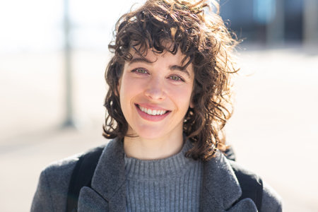 Close-up portrait of attractive young woman in warm coat outside in the cityの写真素材