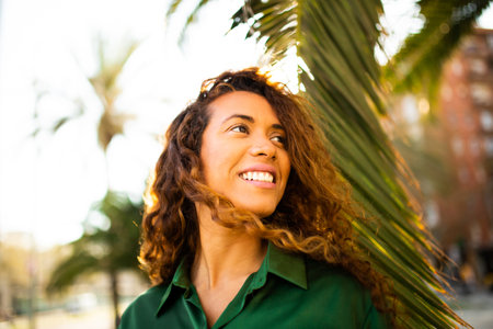 Close up portrait of pretty young latin woman looking away and smiling outside