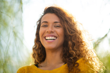 Close up portrait of beautiful young hispanic woman looking at camera outsideの写真素材