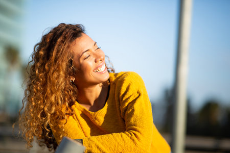 Portrait of happy young latin woman smiling outside in the cityの写真素材