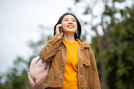 Portrait smiling young asian woman walking with phone and bag