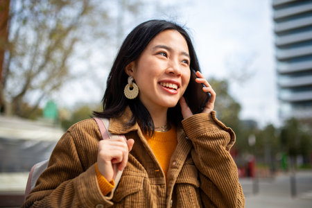 Portrait smiling woman talking with cellphone in cityの写真素材
